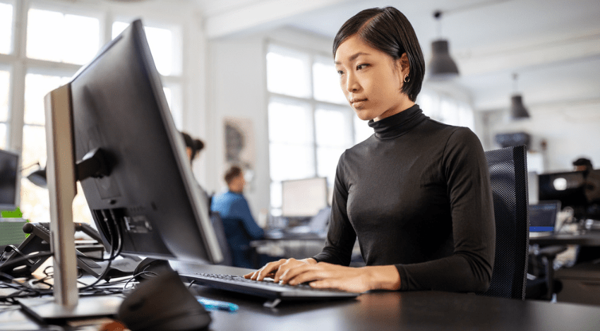 デスクトップ型パソコンで作業する女性